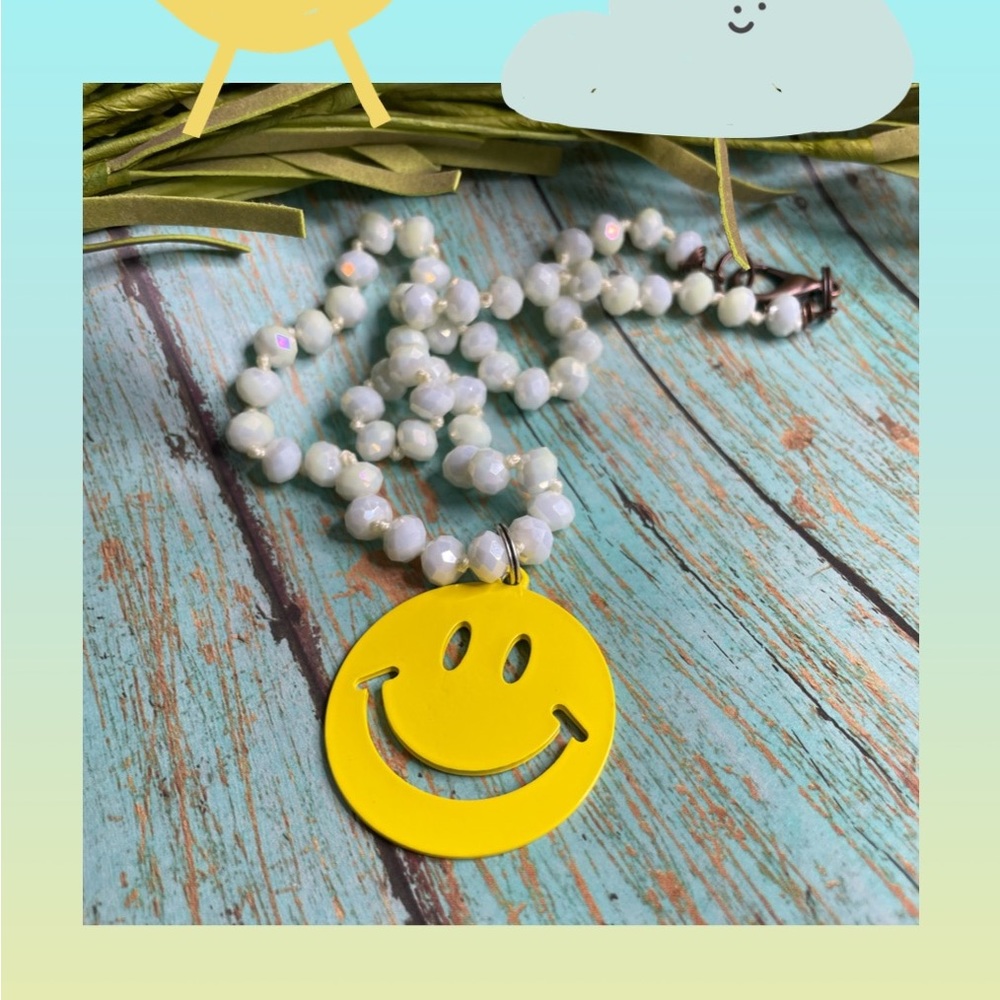 Yellow smiley face pendant on 18” white crystal necklace.